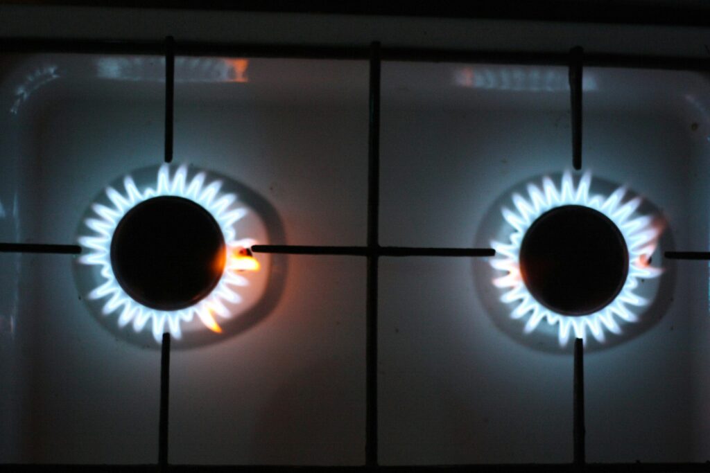 Two gas cooker rings lit with blue flames