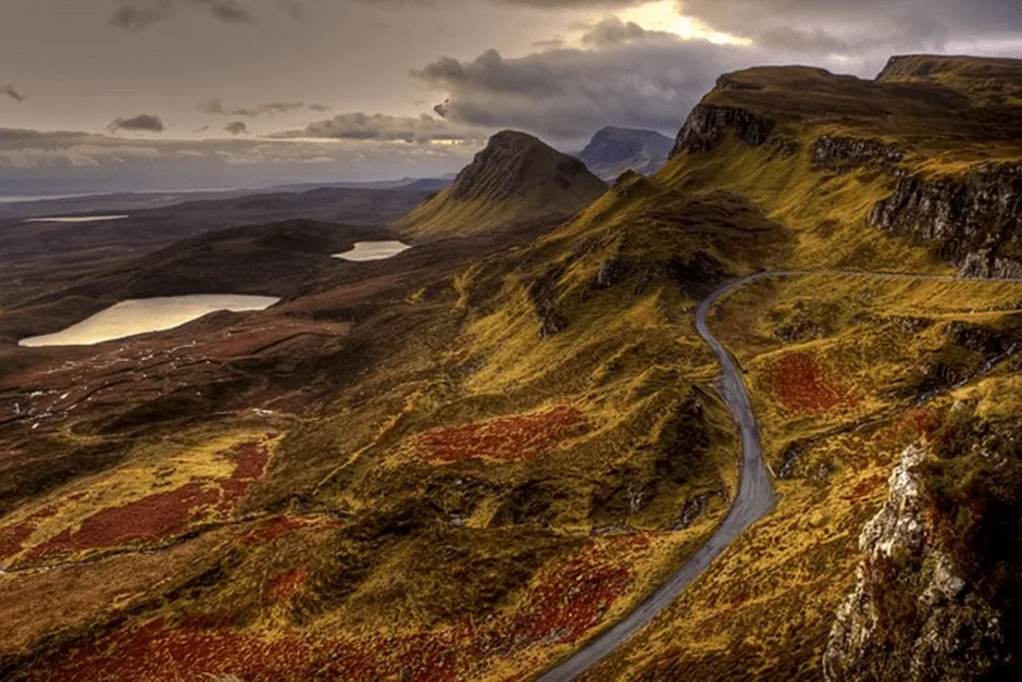 Road winding round mountains at sunset