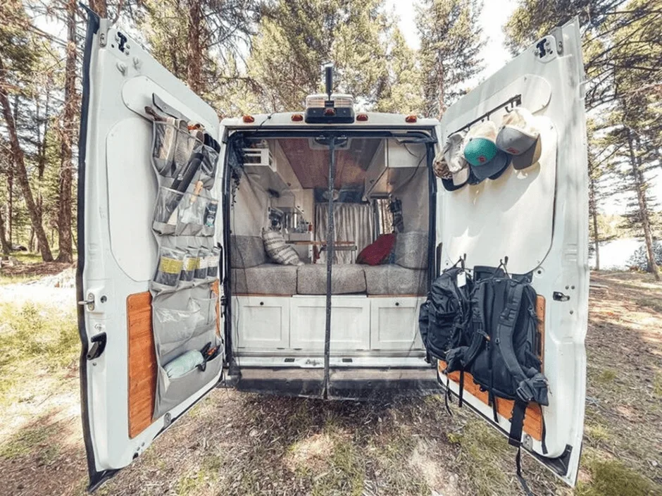 campervan with open back doors showing bed and storage