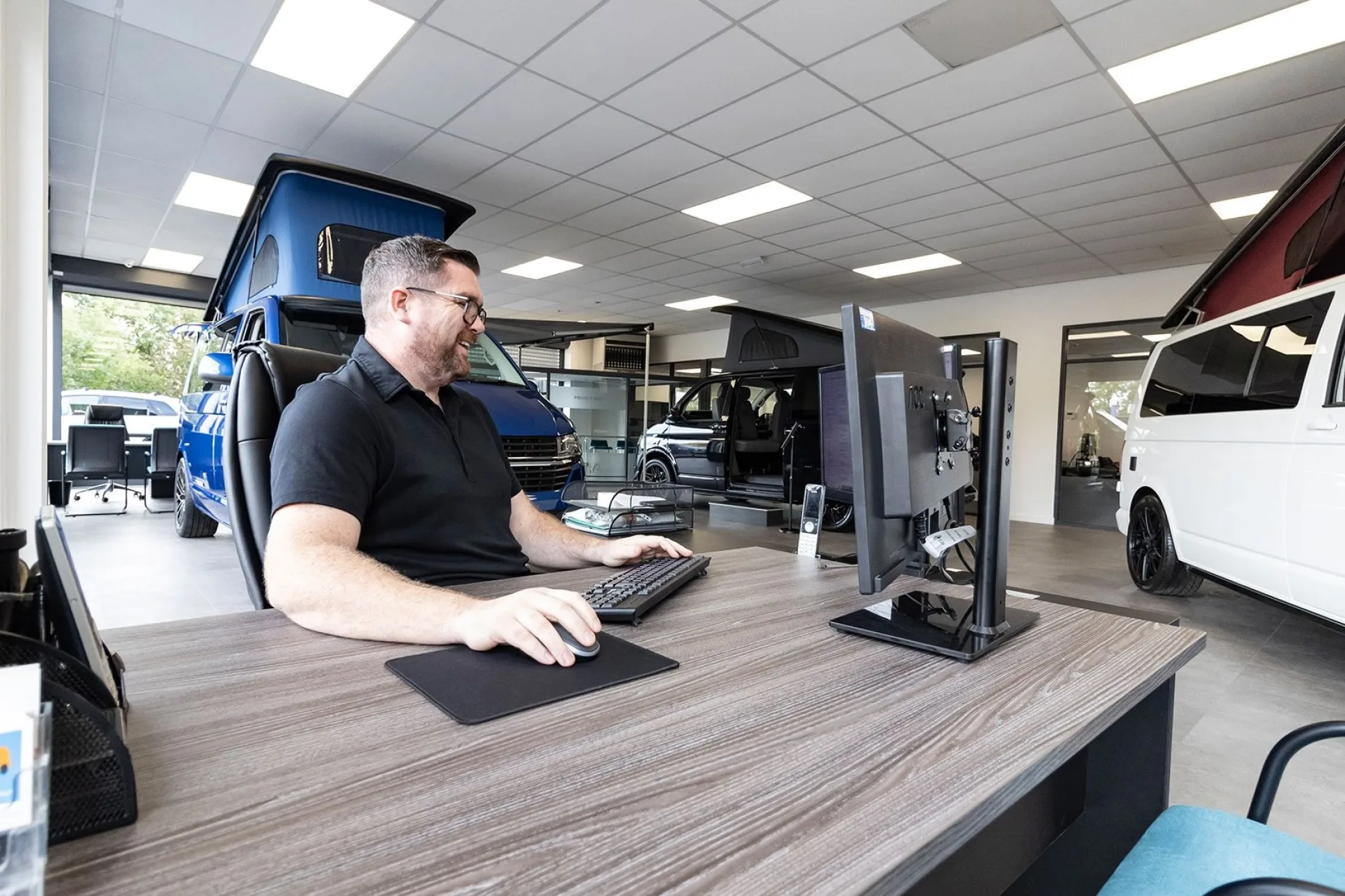 Platinum Wave team member at a computer in camper van showroom