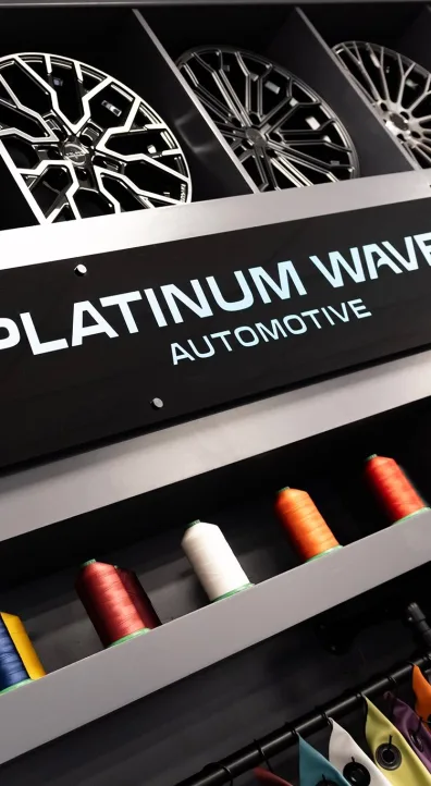 Platinum Wave Automotive sign in-between two shelves filled with wheels and thread spools