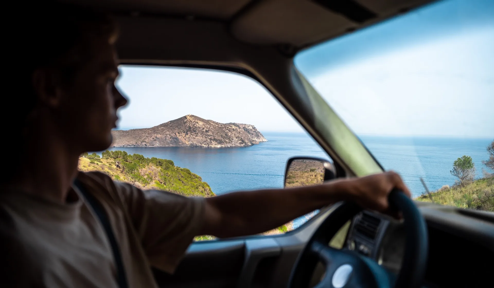 Man driving a camper van next to the sea