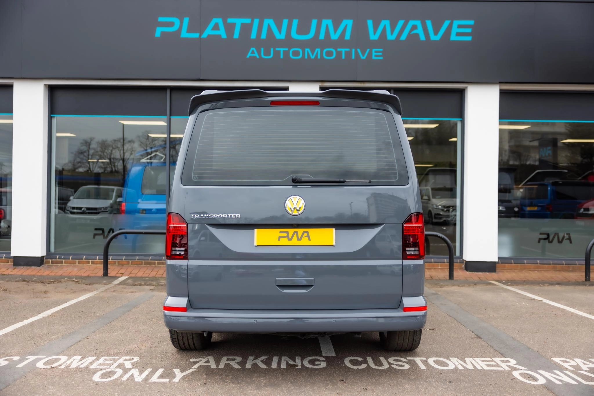 A grey VW transporter campervan parked outside of Platinum Wave Automotive