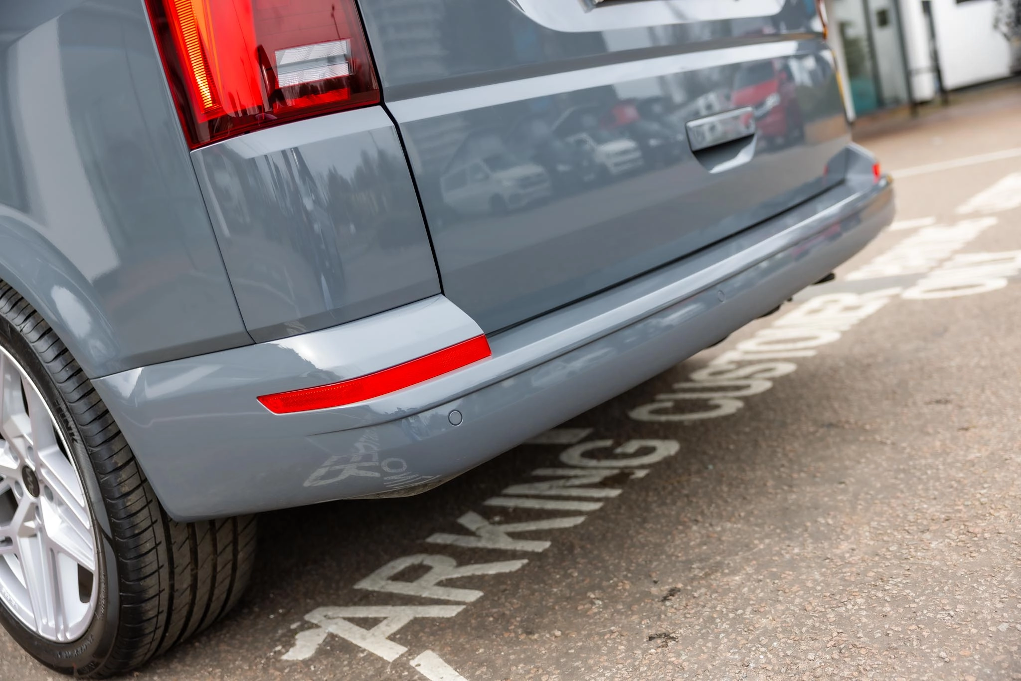 The back bumper and back door of a grey campervan