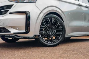 Close up of black wheels on a silver kombi van