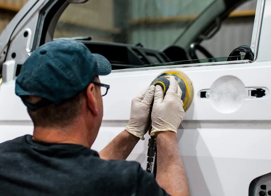 Platinum Wave Automotive employee buffing a white campervan
